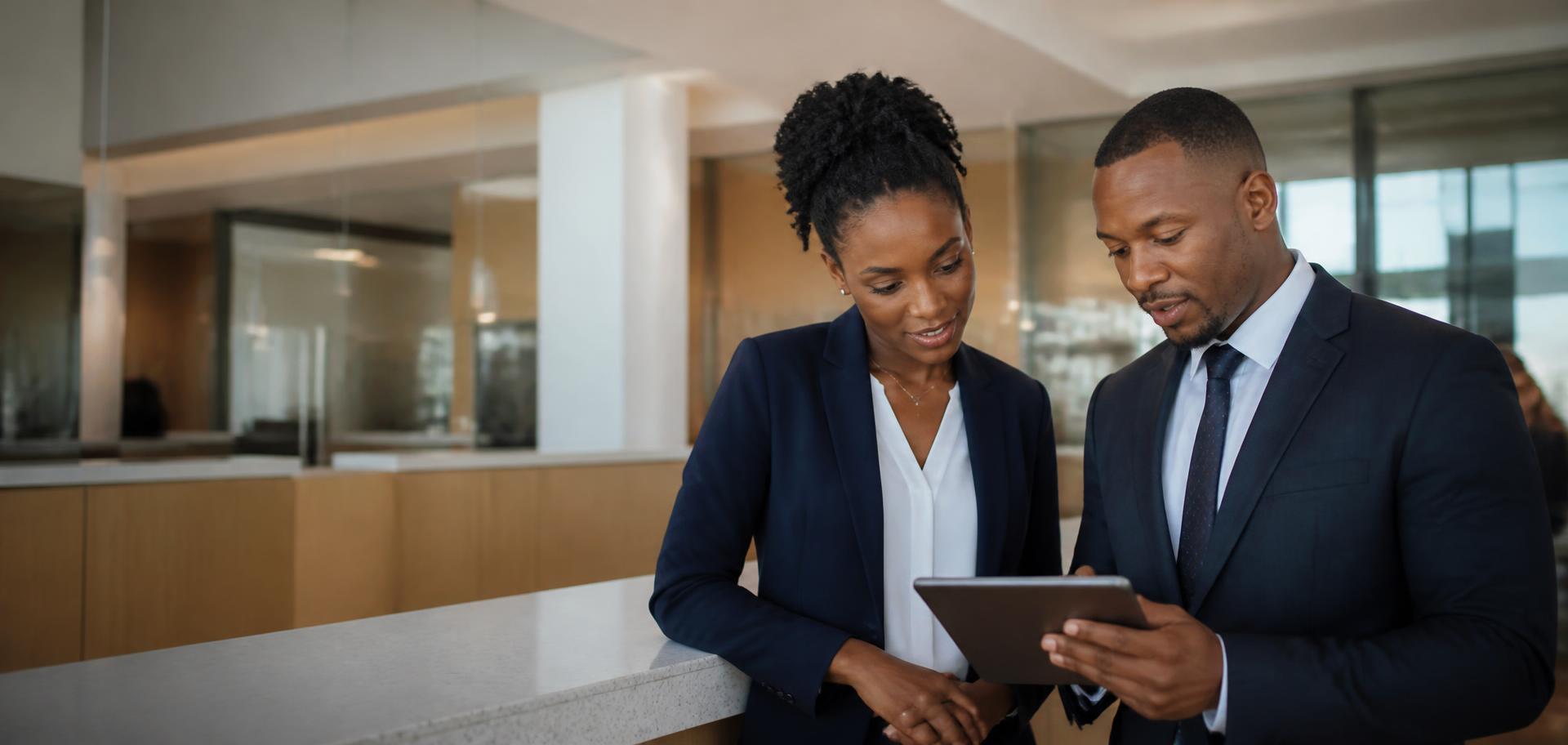 Caribbean financial-services professionals reviewing work together in a modern credit union branch